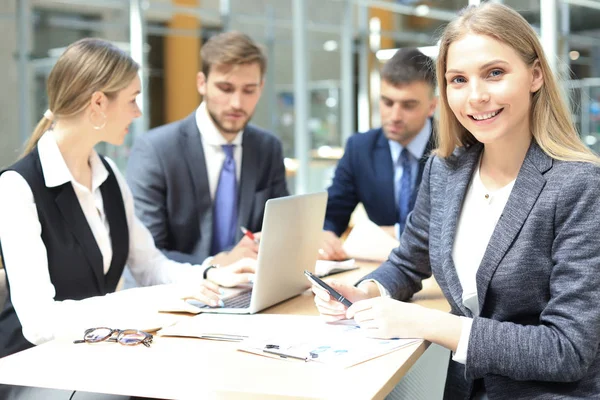 Бизнес-женщина со своим персоналом, люди группируются на заднем плане в современном ярком офисе в помещении. — стоковое фото