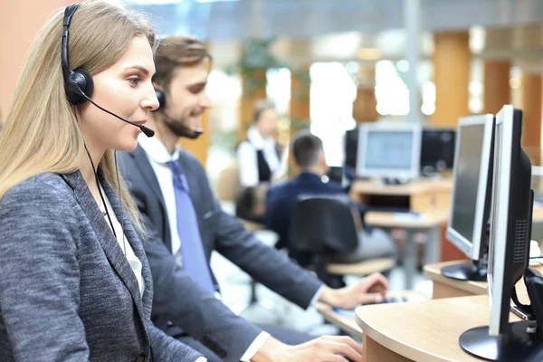 Operadora de atención al cliente femenina con auriculares y sonrisa. —  Fotos de Stock