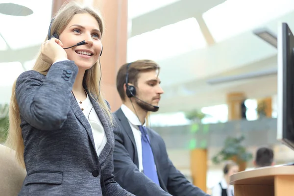 Operadora de suporte ao cliente feminina com fone de ouvido e sorrindo. — Fotografia de Stock