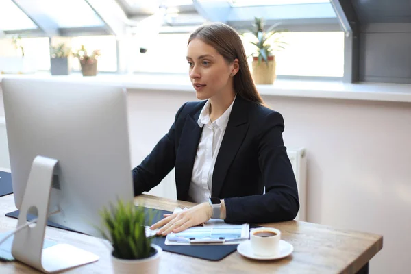 Retrato de una joven mujer de negocios rubia usando computadora en la oficina . — Foto de Stock