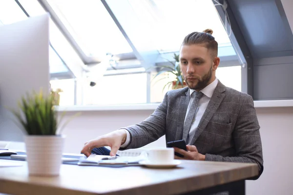 Portrait of young man sitting at his desk in the office. — Stock Photo, Image