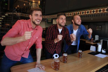 Barda futbol izliyorum. Mutlu arkadaşlar bira içme ve favori takım için tezahürat, zafer kutluyor.