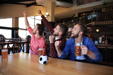 Barda futbol izliyorum. Mutlu arkadaşlar bira içme ve favori takım için tezahürat, zafer kutluyor.