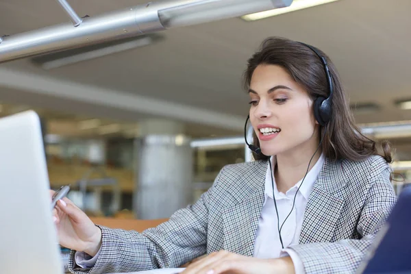 Γυναίκα χειριστή υποστήριξης πελατών με ακουστικά και χαμογελώντας. — Φωτογραφία Αρχείου