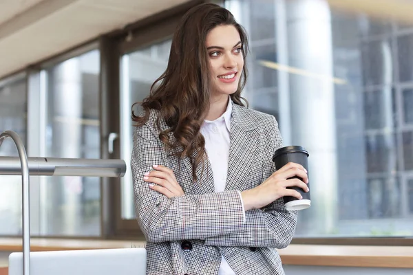 Belle femme d'affaires souriante debout dans le bureau avec une tasse de café . — Photo