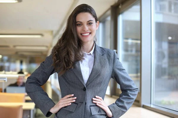 Atractiva mujer de negocios de pie cerca del escritorio en la oficina. — Foto de Stock