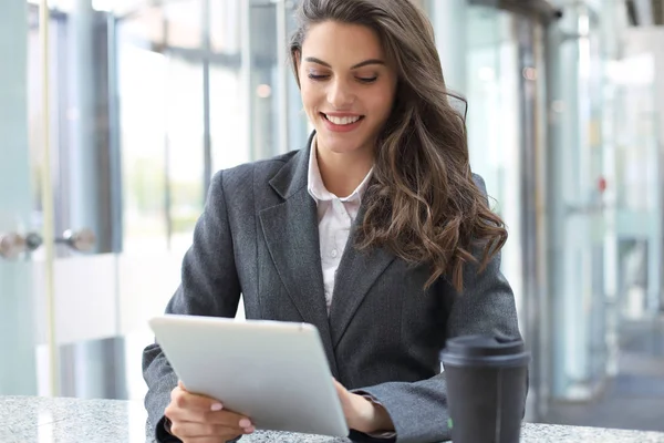 Jeune femme d'affaires souriante au bureau travaillant sur tablette numérique . — Photo