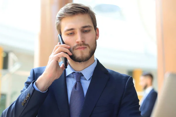 Homme d'affaires utilisant son téléphone portable dans le bureau. — Photo