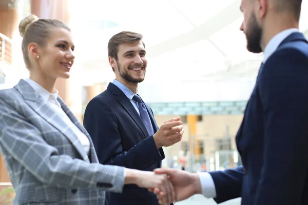 Welcome to our team. Young modern businessmen shaking hands while working in the creative office.