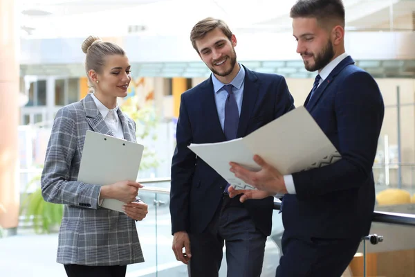 Drie jonge zakenlui die op een kantoor vergadering over zaken praten. — Stockfoto