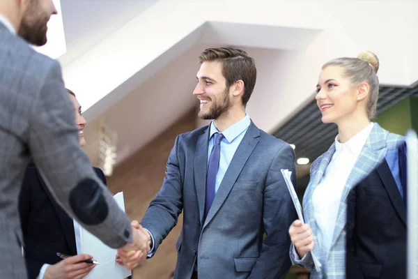 Partner commerciali che stringono le mani sugli oggetti aziendali sul posto di lavoro. — Foto Stock