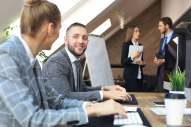 Modern ofis alanı, masaüstü bilgisayarlarında çalışan genç iş adamları.