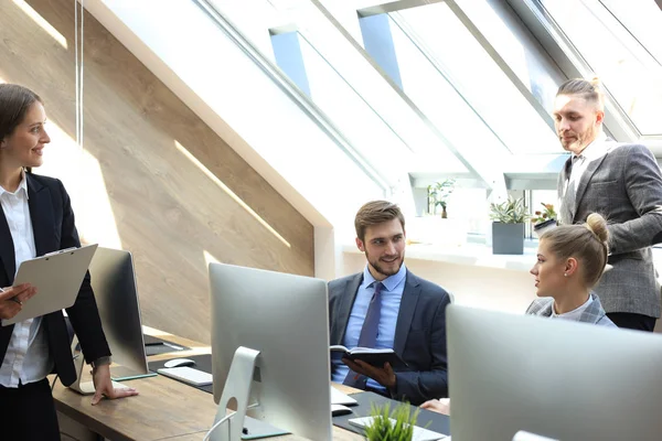 Affärspartners diskuterar dokument och idéer vid mötet. — Stockfoto