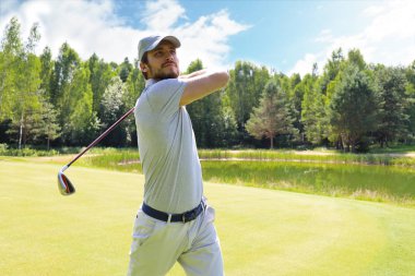 Golfçü yaz tatilinde golf sahasında golf sahasını vuruyor..