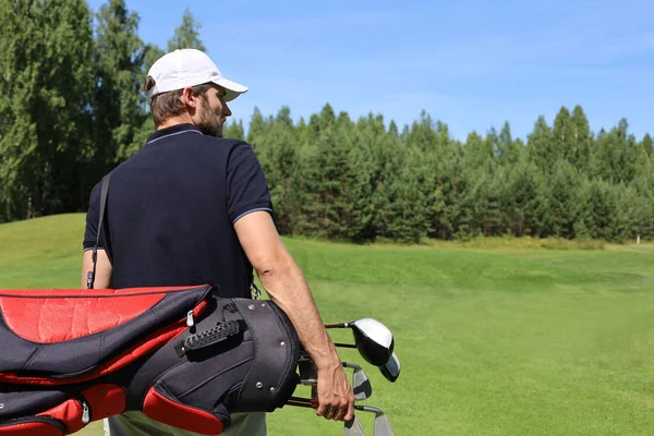 Golf player walking and carrying bag on course during summer game golfing. — Stock Photo, Image
