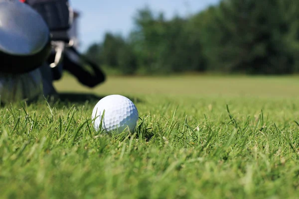 La pelota de golf y el pin están listos para jugar, colocados en un césped verde con un fondo natural . — Foto de Stock