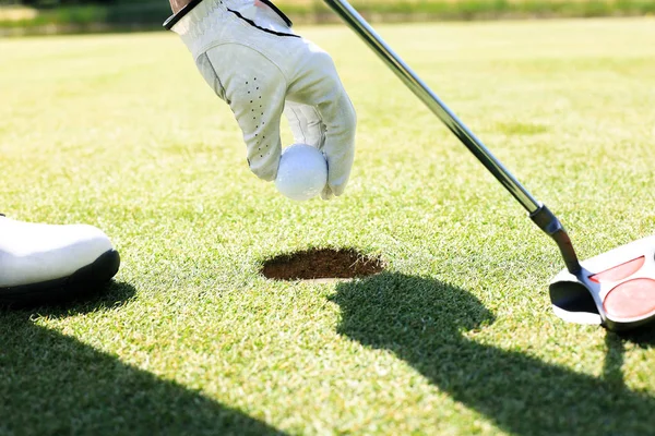 골프 플레이어는 구멍에서 공을 걸립니다. — 스톡 사진