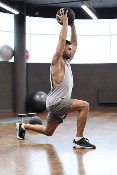 Dopasowanie i muskularny Człowiek ćwiczącego z medycyny piłkę na siłowni. — Zdjęcie stockowe