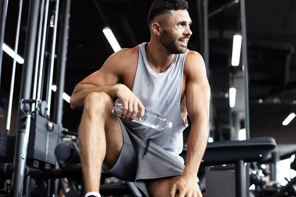 Homem desportivo descansando, tendo quebrar a água potável depois de fazer exercício . — Fotografia de Stock