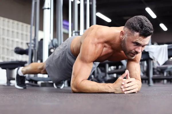 Portret mężczyzny fitness robi szalunki ćwiczeń w siłowni. — Zdjęcie stockowe