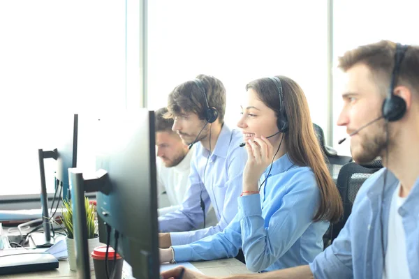 Atractivos jóvenes empresarios y colegas positivos en una oficina de call center. —  Fotos de Stock