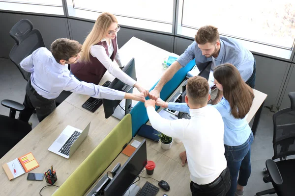 Visão superior de jovens colegas modernos em desgaste casual inteligente trabalhando juntos enquanto passam tempo no escritório . — Fotografia de Stock