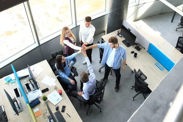 Vue d'ensemble de jeunes collègues modernes en tenue décontractée intelligente travaillant ensemble tout en passant du temps au bureau . — Photo