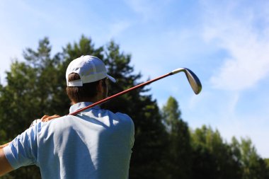 Golf kulübünde golf oynayan atletik genç adam.