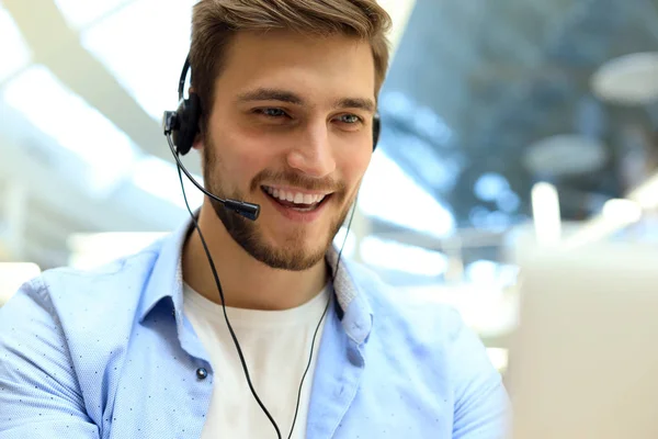 Lachend vriendelijke knappe jonge mannelijke call center operator. — Stockfoto