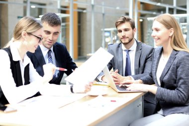 Bir grup iş ortağı ofiste fikir ve planlama işini tartışıyor..