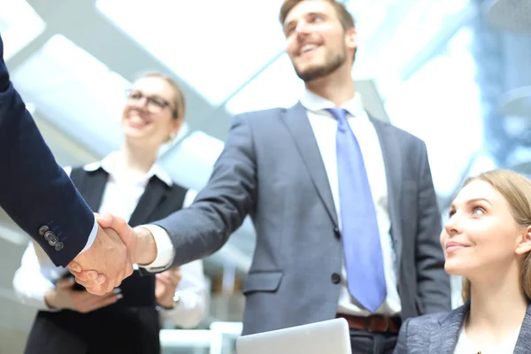 Welkom bij ons team. Jonge moderne zakenlieden schudden de handen terwijl ze werken in het creatieve kantoor. — Stockfoto