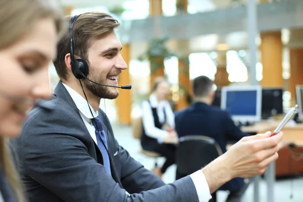 Ritratto di operatore del call center accompagnato dalla sua squadra. Operatore di assistenza clienti sorridente al lavoro. — Foto Stock