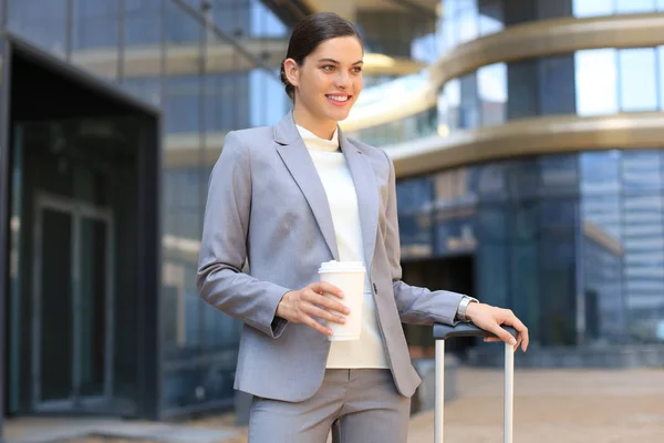 Portrait d'une femme d'affaires prospère allant travailler avec un café marchant près d'un immeuble de bureaux dans la rue de la ville. — Photo