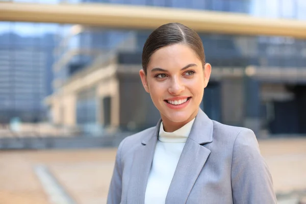 Portret van stijlvolle lachende zakenvrouw in modieuze kleding in de grote stad doelgericht op zoek. — Stockfoto