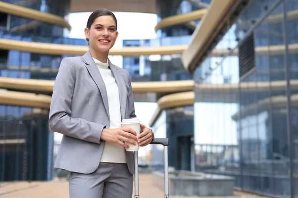 Retrato de una exitosa mujer de negocios que va a trabajar con café caminando cerca del edificio de oficinas en la calle de la ciudad. — Foto de Stock