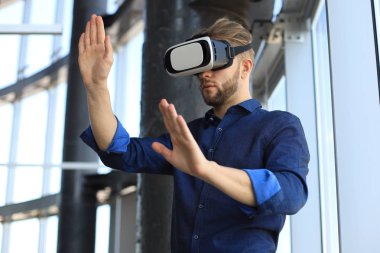 Yeni bir binada VR kulaklık takan bir mühendisin fotoğrafı. Dünyaya bakış açını ve deneyimini değiştir..