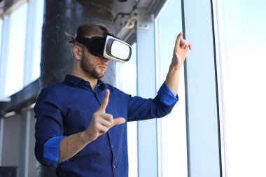 Yeni bir binada VR kulaklık takan bir mühendisin fotoğrafı. Dünyaya bakış açını ve deneyimini değiştir..