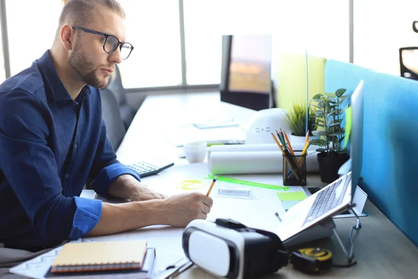 Skjuten av en stilig manlig arkitekt som arbetar med en design på sitt kontor. — Stockfoto