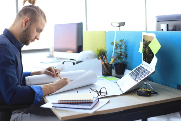 Joven guapo usando el plano mientras trabaja en el espacio de trabajo creativo . — Foto de Stock