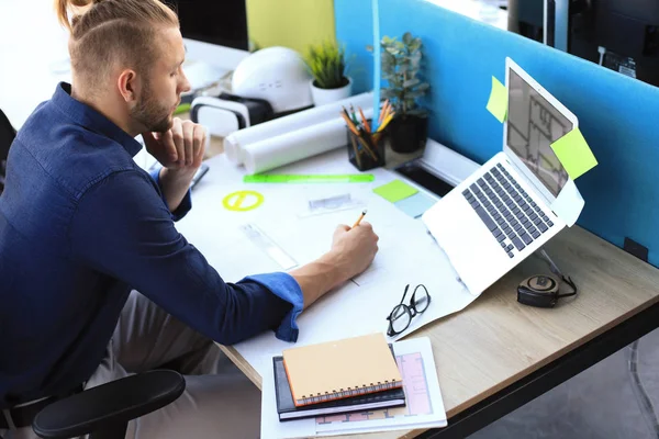 Skjuten av en stilig manlig arkitekt som arbetar med en design på sitt kontor. — Stockfoto