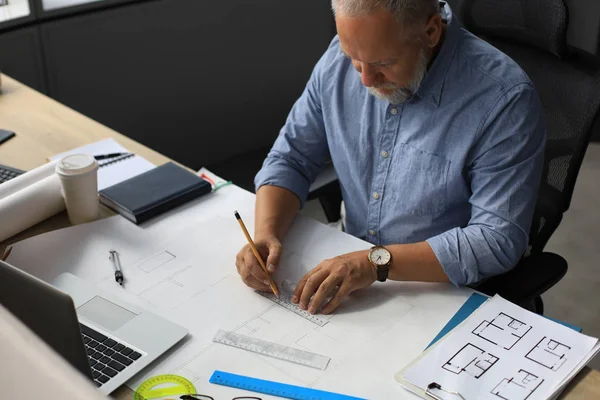 Snygg mogen arkitekt ritar något när han arbetar på kontoret. — Stockfoto