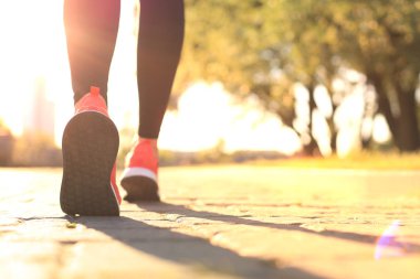 Koşan ayaklar yolda, ayakkabıya yakın, gün batımında ya da gün doğumunda dışarıda..