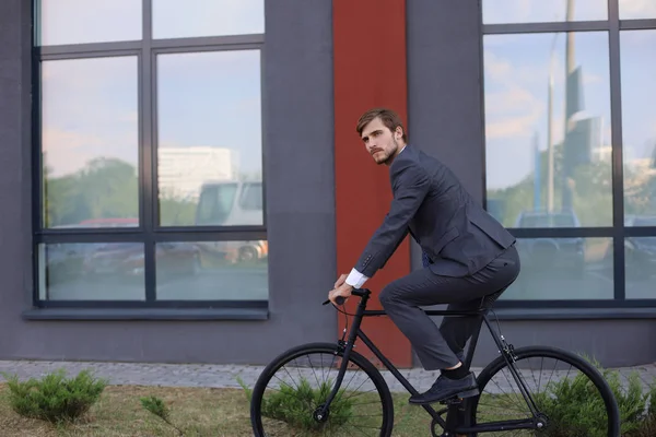 Όμορφος νεαρός επιχειρηματίας που καβαλάει το ποδήλατό του στην πόλη. Έννοια της οικολογικής μεταφοράς. — Φωτογραφία Αρχείου