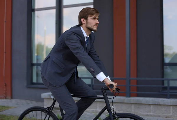 Schöner junger Geschäftsmann, der mit dem Fahrrad in der Stadt unterwegs ist. Ökologisches Verkehrskonzept. — Stockfoto