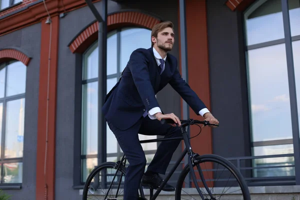 朝の都市通りに仕事のためのハンサムな実業家乗馬自転車. — ストック写真