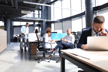 Yaratıcı ofiste birlikte yeni proje üzerinde çalışan mutlu ilerici iş adamları grubu