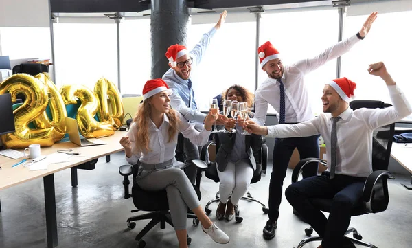 Gli uomini d'affari festeggiano le vacanze nel moderno ufficio bevendo champagne e divertendosi nel coworking. Buon Natale e Felice Anno Nuovo 2020 . — Foto Stock