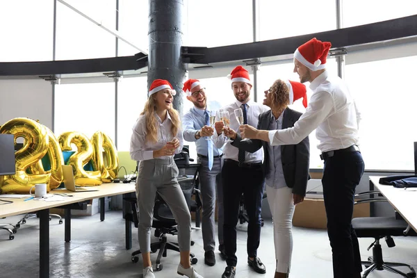 Gli uomini d'affari festeggiano le vacanze nel moderno ufficio bevendo champagne e divertendosi nel coworking. Buon Natale e Felice Anno Nuovo 2020 . — Foto Stock