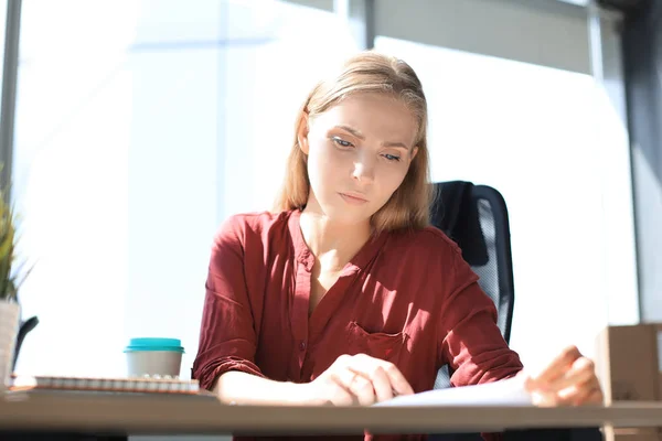 Красива бізнес-леді розглядає документи, сидячи в офісі — стокове фото