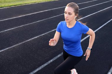 Sporcu atletizm pistinde koşuyor. Stadyumda kardiyo antrenmanı yapıyor. Yarışma için hızlı koşuyor